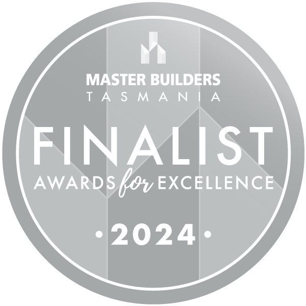Silver circular badge with the text: Master Builders Tasmania Finalist Awards for Excellence 2024, set against a geometric background.